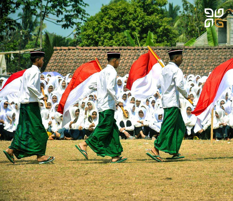 Pelajar mengenakan pakaian adat membawa bendera Merah Putih dalam kegiatan lingkungan